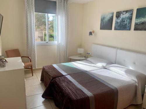 a bedroom with a large bed and a window at Can Antonia in Can Picafort