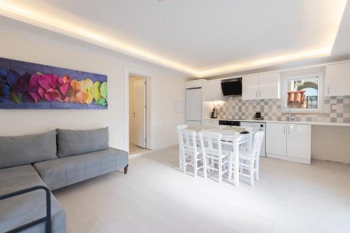 a white living room with a couch and a table at Soothe Hotel in Kalkan