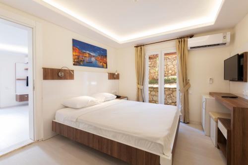 a bedroom with a large bed and a television at Soothe Hotel in Kalkan