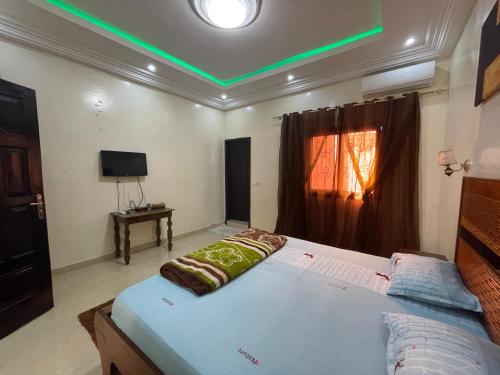 a bedroom with a large bed with a green light at Villa soleil du Sénégal in Dakar