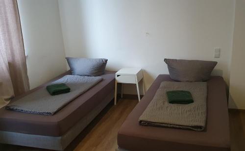 2 Betten in einem kleinen Zimmer mit einem Tisch in der Unterkunft Hotel Berkut in Fürth