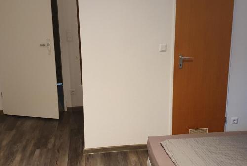 a bedroom with a bed and a door and wooden floors at Hotel Berkut in Fürth