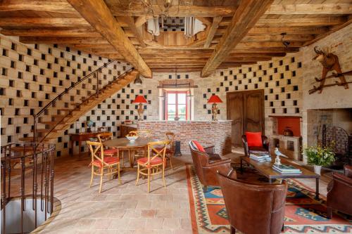 a living room with a table and chairs at Le Domaine de Ravenoville - Pierres d'Histoire in Ravenoville