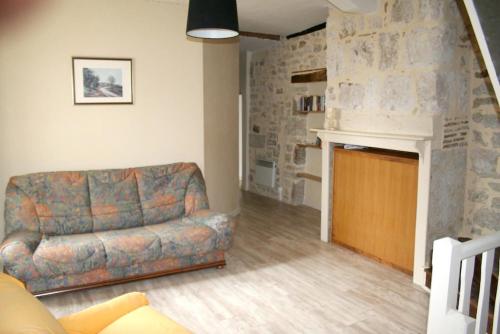 a living room with a couch and a fireplace at Villa charmante à Montfaucon avec piscine privée in Montfaucon