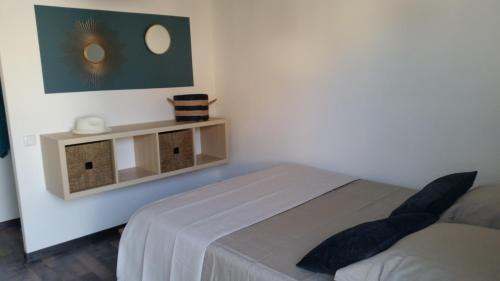 Dieses weiße Zimmer verfügt über ein Bett, ein Regal und ein Bett. in der Unterkunft TIBOU PLAGE in Marseille
