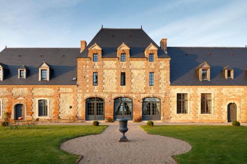 a large brick building with a black roof at Le Domaine de Ravenoville - Pierres d'Histoire in Ravenoville