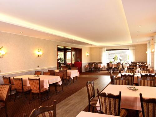 a restaurant with tables and chairs in a room at Gasthof "Zum Burghof" in Medebach