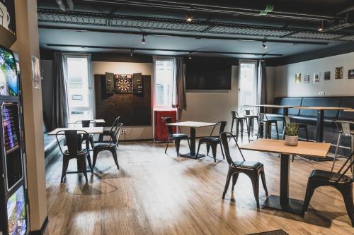 a restaurant with tables and chairs in a room at Das Schlafwerk Stuttgart-Nord VOLLDIGITALES HOTEL-SELF-CHECK IN - keine Rezeption-LowBudget-cashless in Korntal-Münchingen