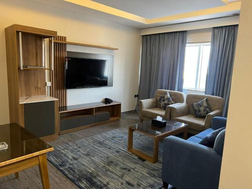 a living room with a couch and a tv at PRIMOTEL Elite As Salamah in Jeddah