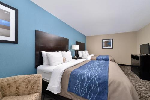 a hotel room with two beds and a chair at Comfort Inn & Suites Springfield I-55 in Springfield