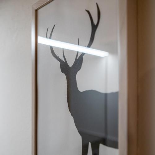 a painting of a deer on a wall with a light at Cachettes in La Salle