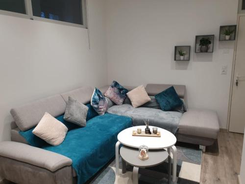 a living room with a couch and a table at Appartement COSY et chaleureux in Lons-le-Saunier