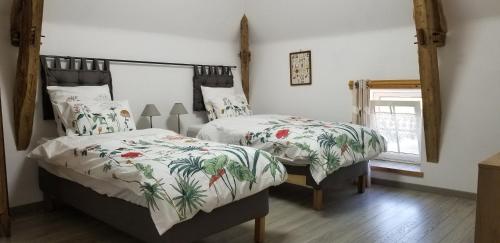 a bedroom with two beds and a window at Moulin de l'Hoste in Larzac