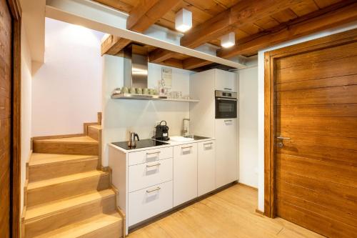 a kitchen with white cabinets and a wooden door at Cachettes in La Salle