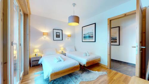 a bedroom with two beds and a mirror at Hauts de Veysonnaz HV1 012 - SAUNA apartment 6 per in Veysonnaz
