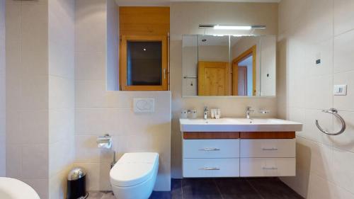 a bathroom with a toilet and a sink and a mirror at Hauts de Veysonnaz HV1 012 - SAUNA apartment 6 per in Veysonnaz