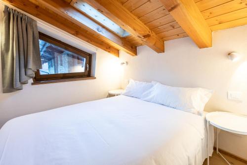a bedroom with a white bed and a window at Cachettes in La Salle