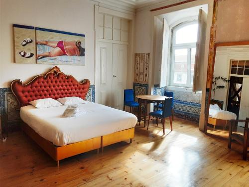 1 dormitorio con 1 cama grande y cabecero rojo en Lisbon Calling, en Lisboa