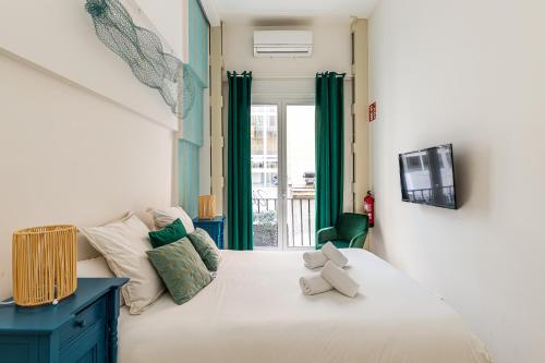 a bedroom with a white bed and a tv at BNBHolder Oasis GRAN VIA in Madrid