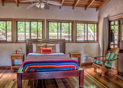 ein Schlafzimmer mit einem Bett mit einer bunten Decke darauf in der Unterkunft Casa Santa Maria in Benque Viejo del Carmen