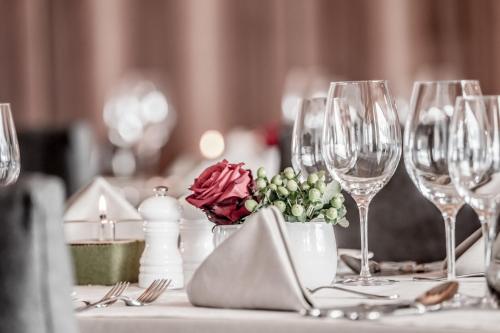 a table with wine glasses and a vase of flowers at Hotel Weisses Lamm in See