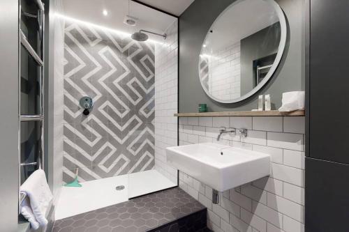 Stylish 2 bedroom 2 bathroom flat in Islington في لندن: حمام مع حوض ومرآة