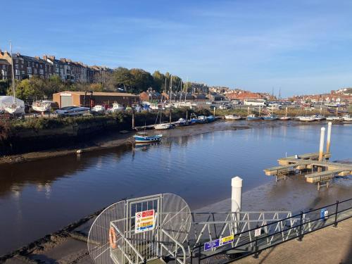 a view of a river with a dock and boats at Swanning Off Whitby with Parking in Whitby