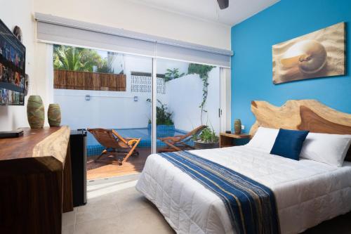 - une chambre avec un lit et une porte coulissante en verre dans l'établissement Villa Sofía Holiday Accommodation, à Cancún
