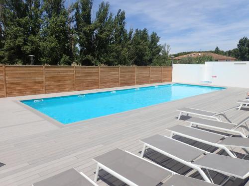 une piscine avec des chaises et une clôture dans l'établissement LES JARDINS D'ATHENA, à Aix-en-Provence