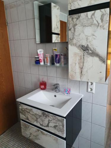a bathroom with a white sink and a mirror at Ferienwohnung Nina direkt in Zentrum in Bad Wildbad