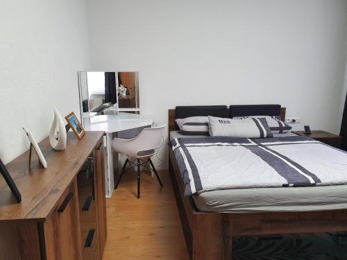 a bedroom with a bed and a desk with a mirror at Ferienwohnung Nina direkt in Zentrum in Bad Wildbad