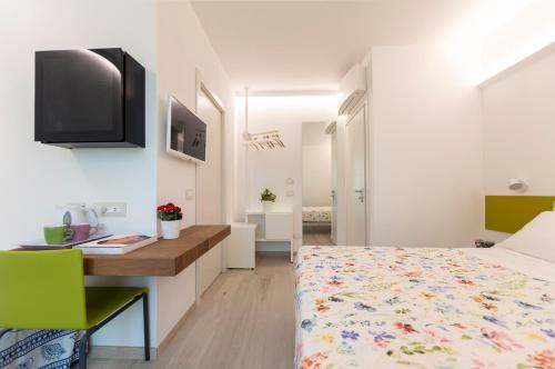 1 dormitorio con 1 cama, escritorio y TV en ARIA Design B&B Levanto, en Levanto