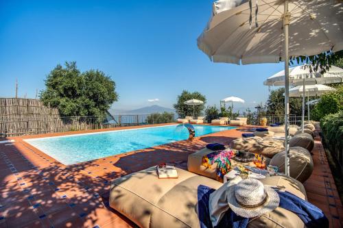 een zwembad met ligstoelen en parasols ernaast bij Relais Palazzo del Barone in Sorrento