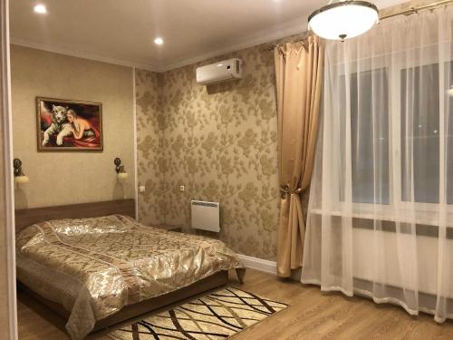 um quarto com uma cama e uma janela em Hotel Karavan em Petrozavodsk