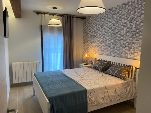 1 dormitorio con cama y pared de ladrillo en SIERRA NORTE-TERVILOR, en Canencia