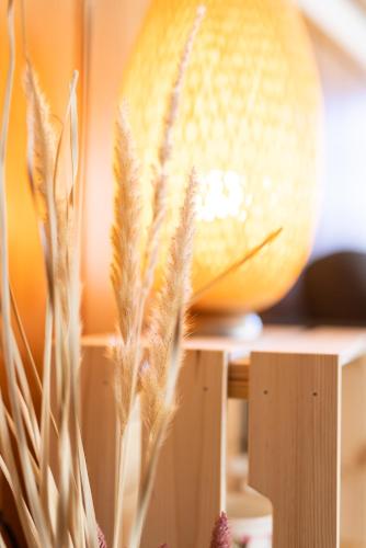 a table with a lamp and some tall grass at KASSNHOF - Urlaub in den Bergen in Telfes im Stubai