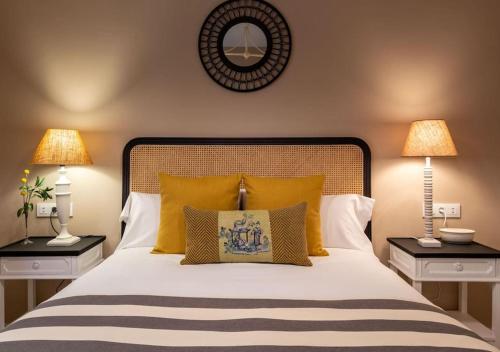 a bedroom with a bed with yellow pillows and two lamps at Plaza Nueva Deluxe Suite by Valcambre in Seville