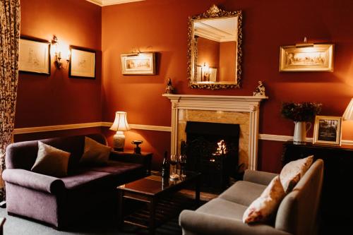 a living room with a fireplace and a mirror at The Boar's Head in Harrogate