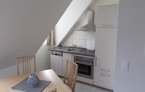 a kitchen with white cabinets and a table and a sink at Domblick Schwerin in Schwerin