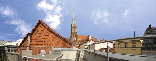 a balcony with a table and a church with a steeple at Domblick Schwerin in Schwerin