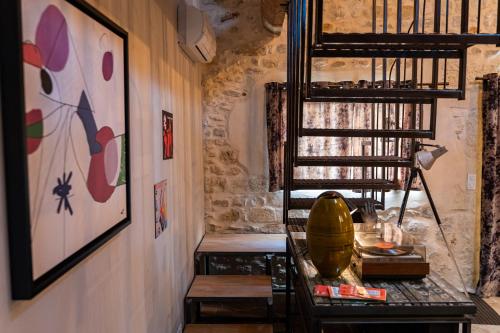 una habitación con una escalera, una mesa y un estante en Domaine Sesquier Mas d'exception Hibiscus en Mèze