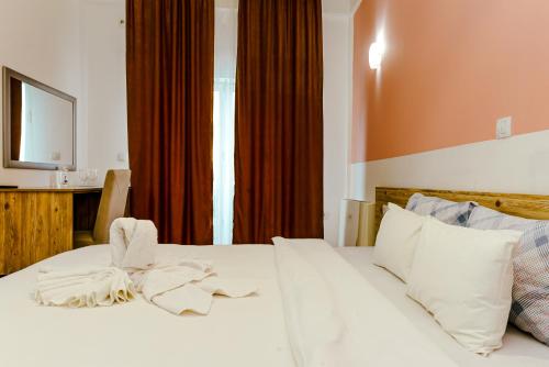 a bedroom with a white bed with a bow on it at Verdisso Hotel & Restaurant in Demir Kapija