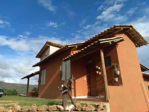 una casa con una estatua delante de ella en Chalé Paz Central do Paraíso Lapinha da Serra, en Santana do Riacho