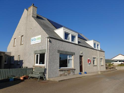 un edificio con un banco delante de él en Bellavista Guest House, en Kirkwall