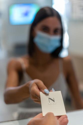 a woman in a mask holding a piece of paper at Nautilus Family Hotel in Pesaro