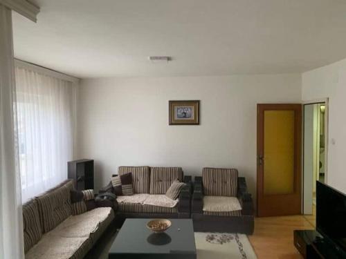 a living room with two couches and a tv at Lovely Hotel & Apartment for rent in center of Gjilan in Gnjilane