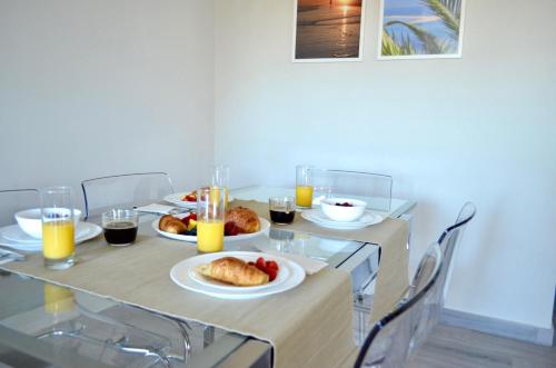 a table with plates of food and glasses of orange juice at Villa ELTAEL - Daniel Apartment - Warm Pool from April 2026 in Manta Rota