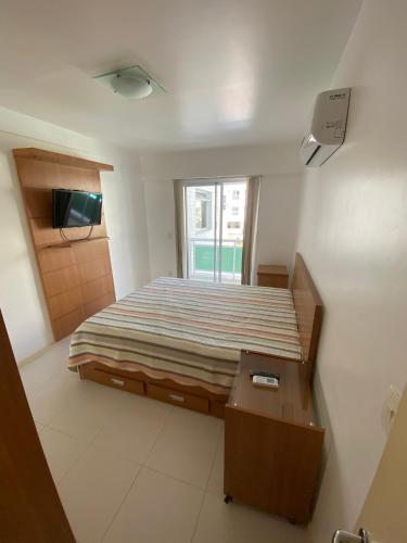 a small bedroom with a bed and a window at Costa Maggiore Residencial Resort in Cabo Frio
