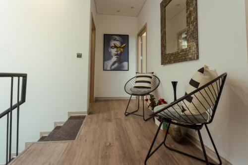 a hallway with two chairs and a mirror on the wall at FLAMINGOS Villa Happy BT in Ngọc Quang