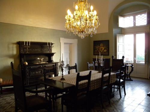 comedor con mesa y lámpara de araña en Villa Franca, en Viagrande